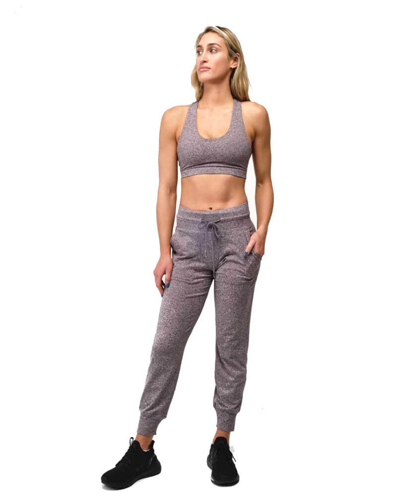 Woman wearing a matching sports bra and jogger set on a white background