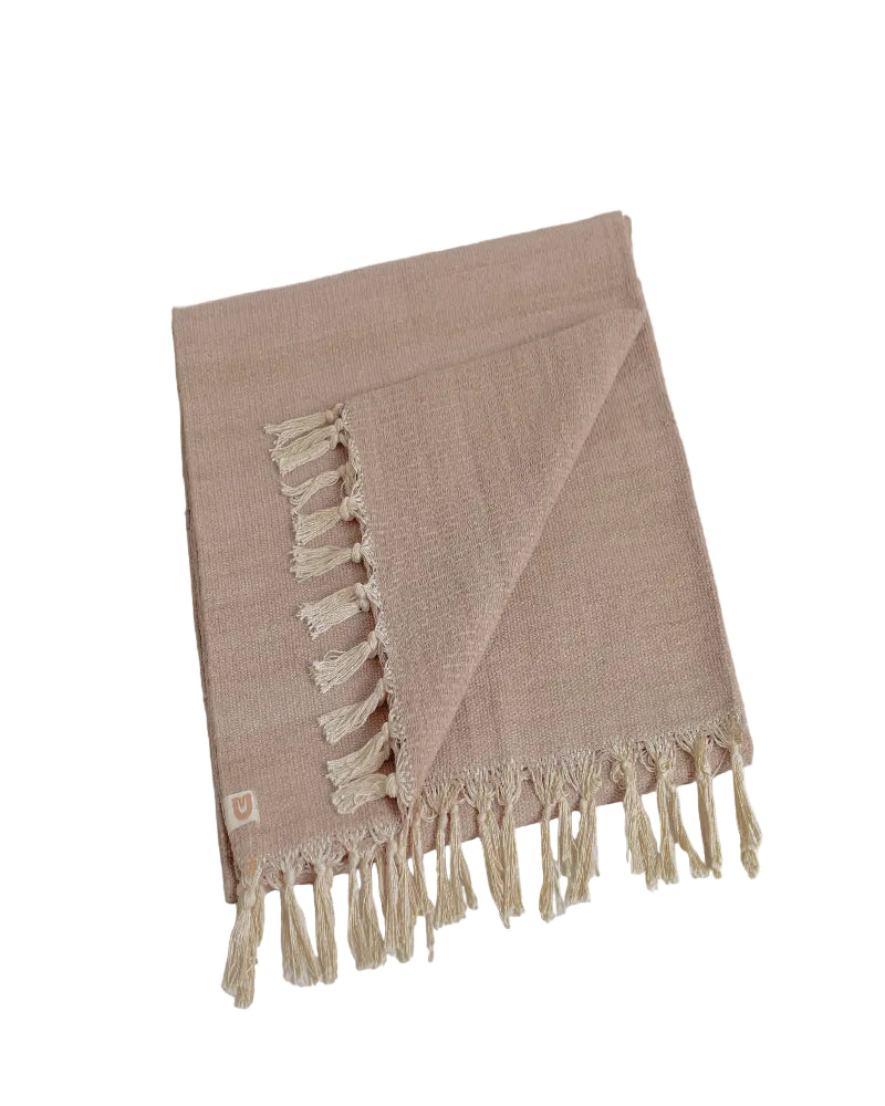 Beige woven blanket with tassels on a white background